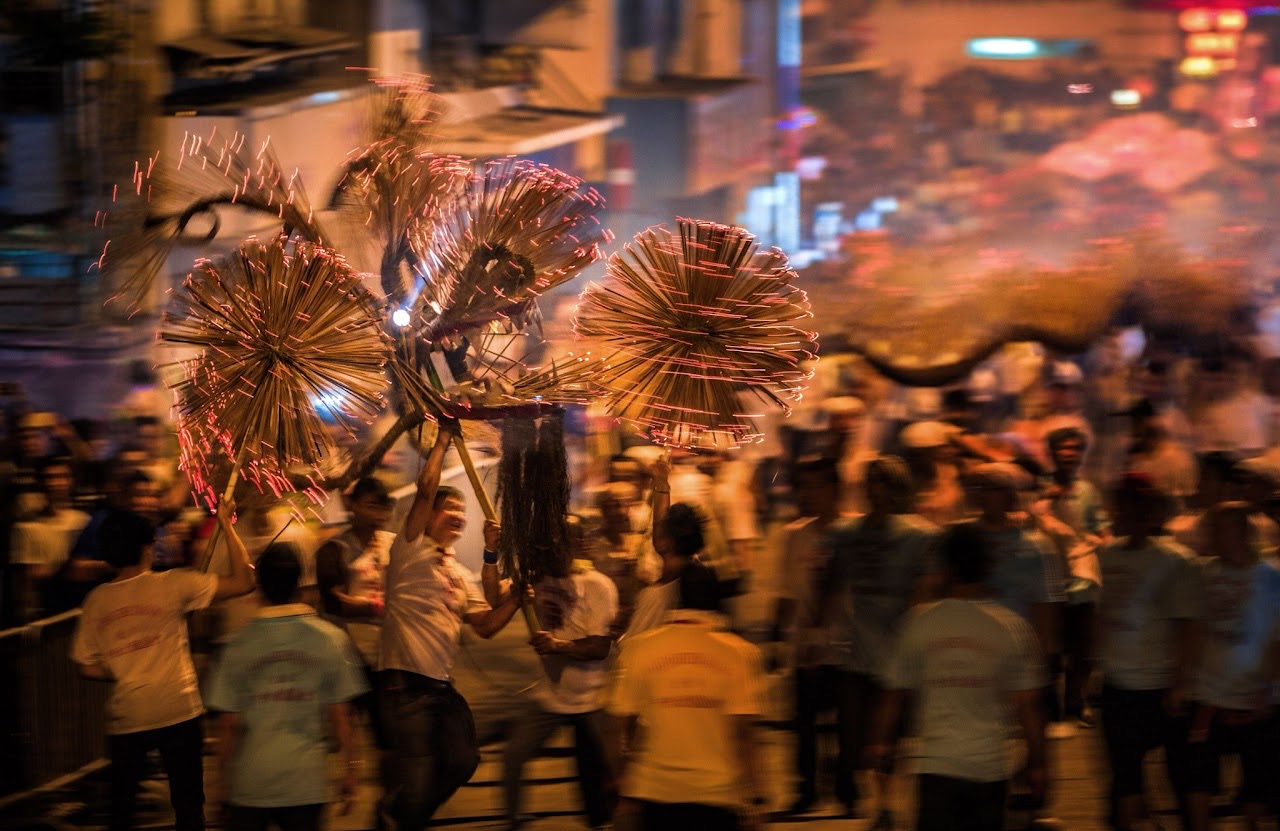 A crowded fire dragon procession at night.