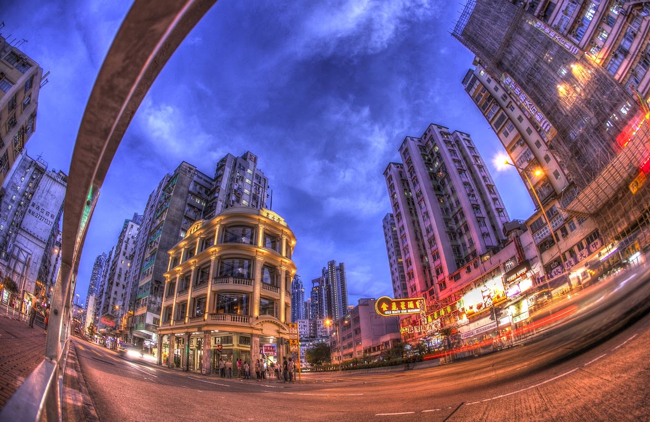 Fisheye view of a Hong Kong street under a dramatic evening sky.