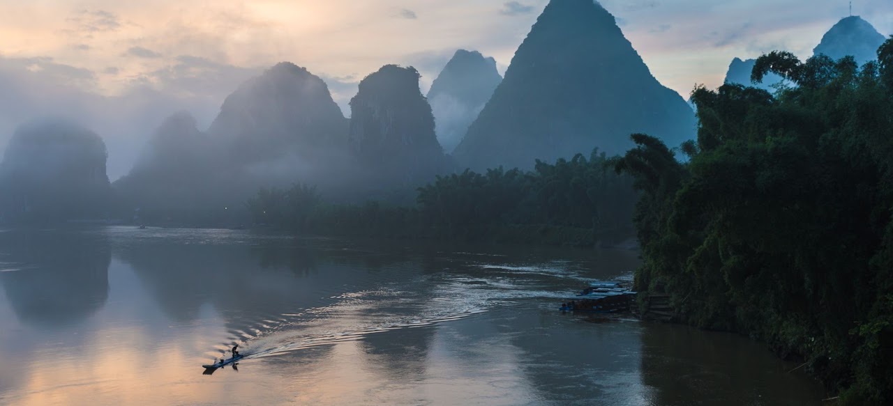 Misty Li River landscape with a small boat.