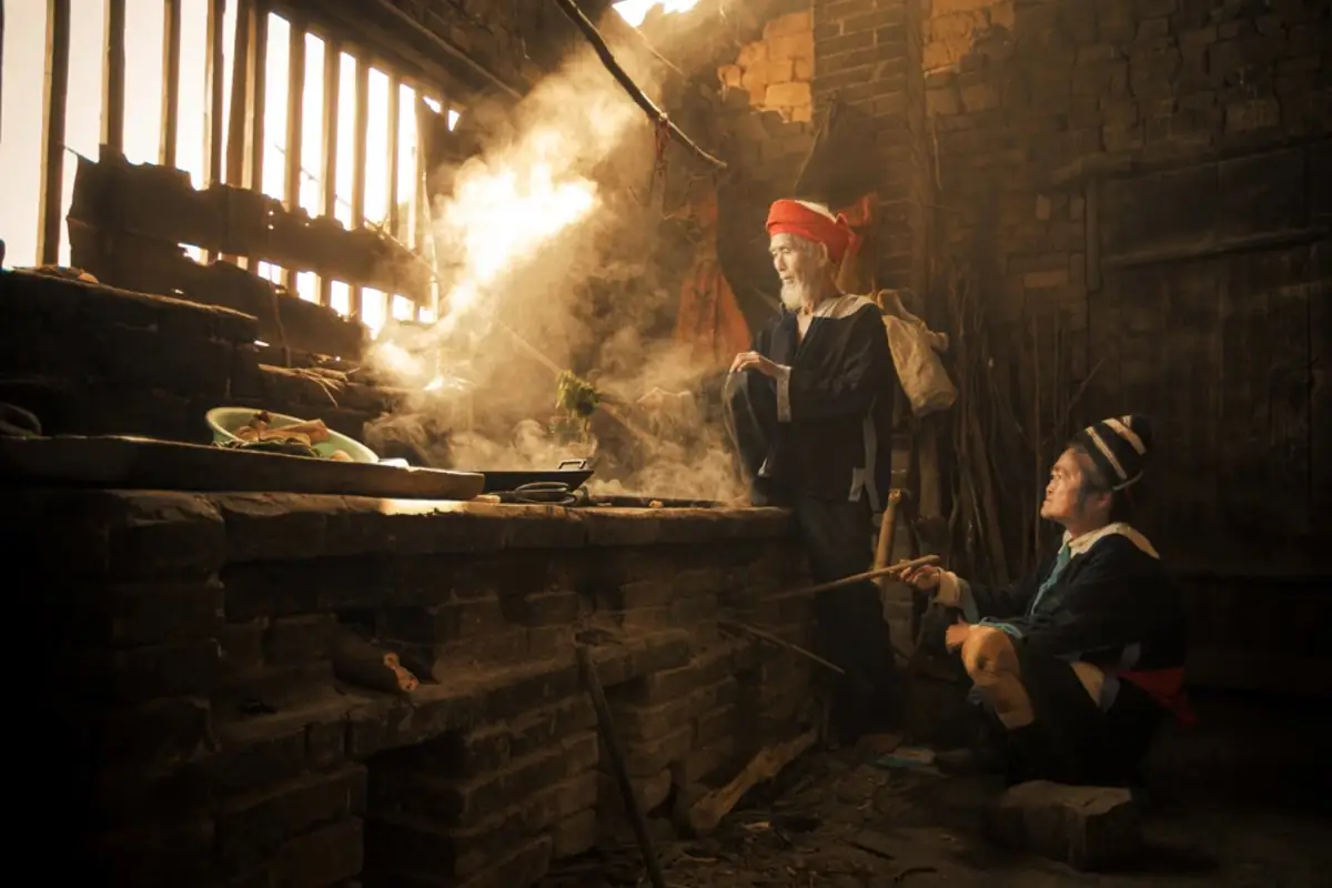 Warm shaft of light and smoke in a rustic kitchen.